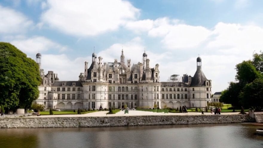 Ornate palace viewed across a formal garden.